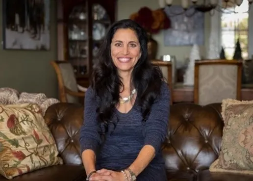 A woman sitting on top of a couch in front of a wall.