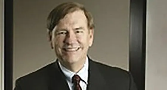 A man in suit and tie smiling for the camera.